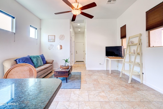 living area featuring visible vents, baseboards, and ceiling fan