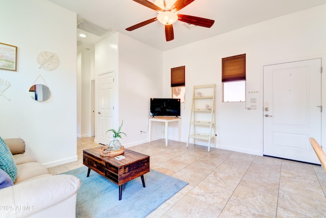 living room with baseboards and a ceiling fan