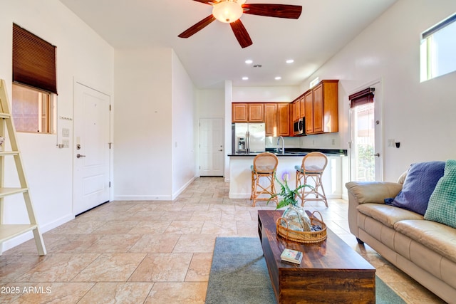 living area featuring recessed lighting, baseboards, and ceiling fan