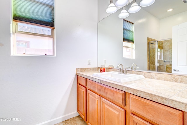 full bath featuring vanity, baseboards, and a stall shower