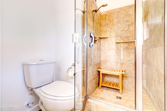 bathroom with a shower stall and toilet