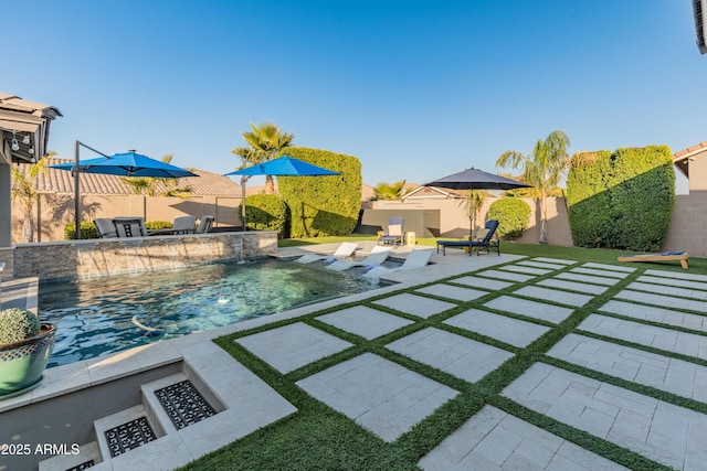 view of pool with pool water feature, a patio area, and a fire pit