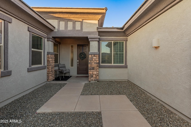 view of exterior entry featuring a patio area