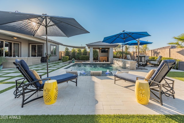 view of swimming pool with pool water feature, an outdoor kitchen, exterior bar, and a patio area