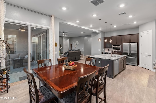 dining area featuring ceiling fan and sink