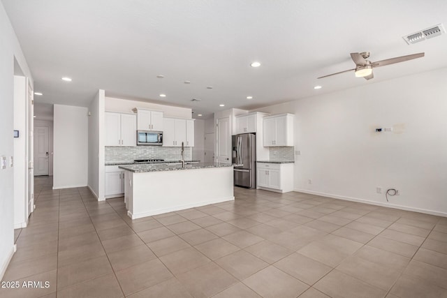 kitchen featuring a kitchen island with sink, visible vents, white cabinetry, open floor plan, and appliances with stainless steel finishes