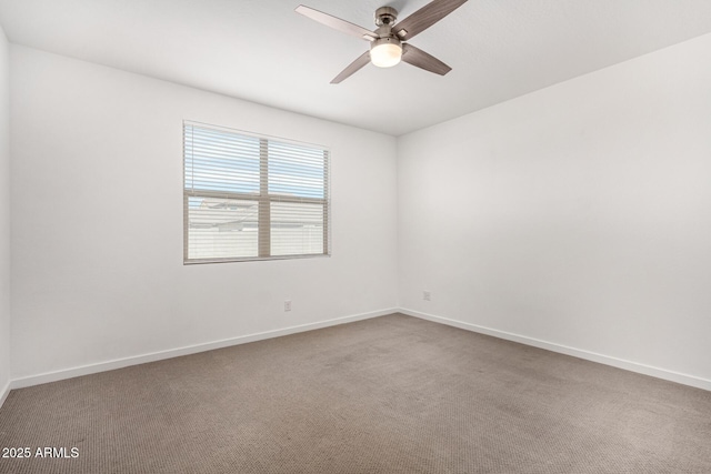 carpeted empty room with a ceiling fan and baseboards