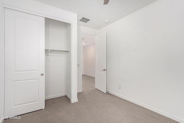 unfurnished bedroom with a closet, carpet flooring, visible vents, and baseboards