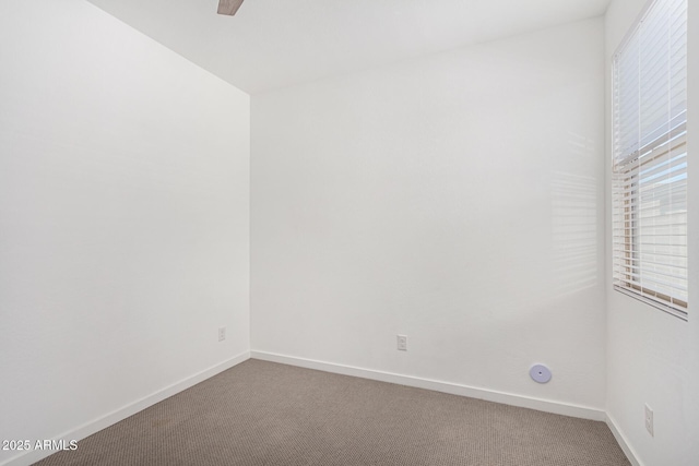 empty room featuring carpet flooring, ceiling fan, and baseboards