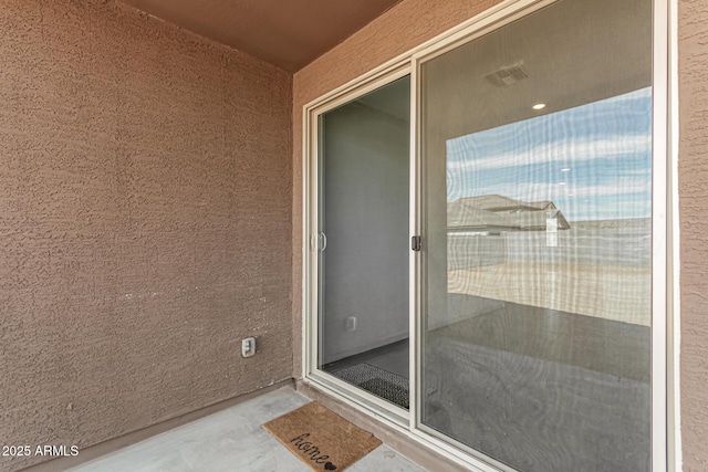 view of exterior entry featuring stucco siding