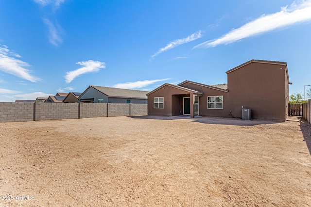 back of property featuring a fenced backyard, a patio, central AC, and stucco siding