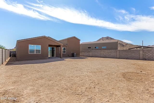 rear view of property with a fenced backyard and stucco siding