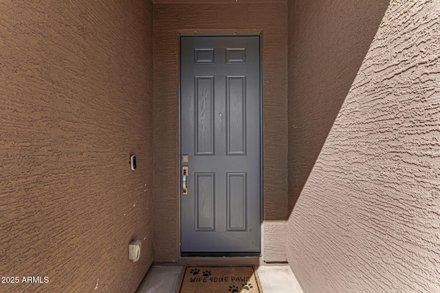 view of exterior entry with stucco siding