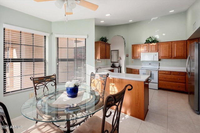 kitchen with backsplash, ceiling fan, light tile patterned floors, and white appliances