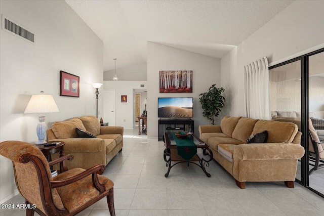 living room with light tile patterned floors, a textured ceiling, and high vaulted ceiling