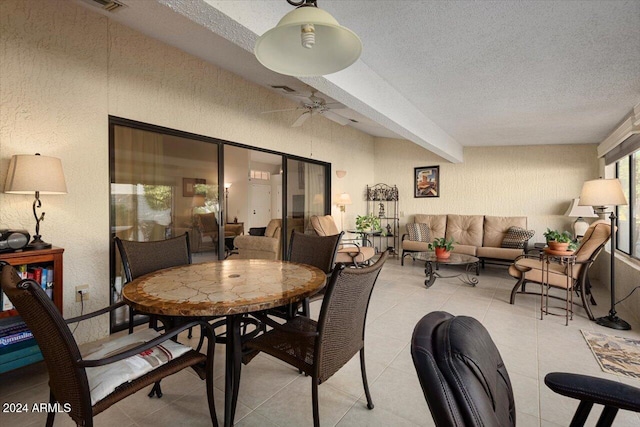 dining space featuring ceiling fan and a textured ceiling