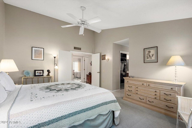 bedroom with ensuite bath, light colored carpet, ceiling fan, a spacious closet, and a closet