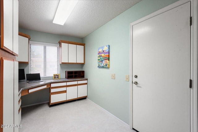 office space featuring a textured ceiling and built in desk