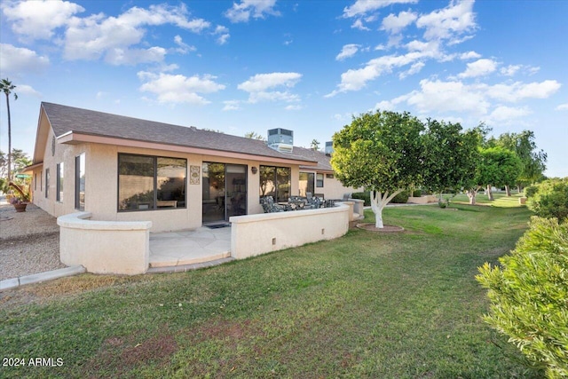 rear view of house with a yard and a patio