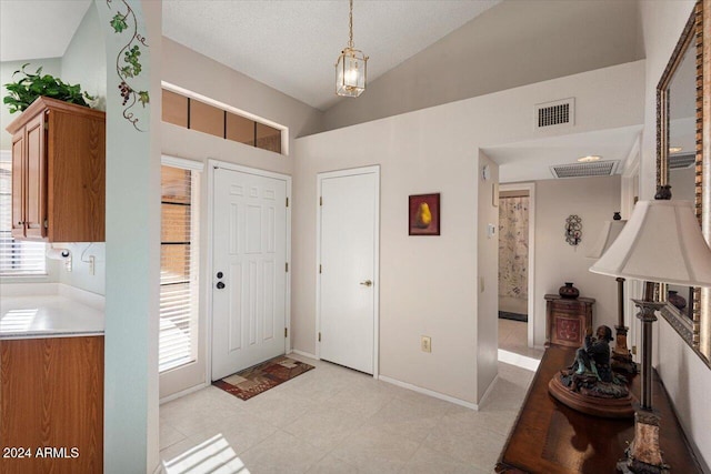 foyer with a textured ceiling and lofted ceiling