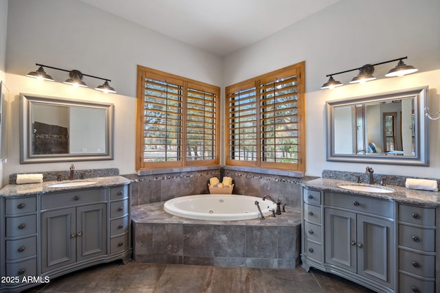 bathroom with a sink, a whirlpool tub, and two vanities