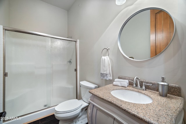 bathroom featuring a shower stall, vanity, and toilet