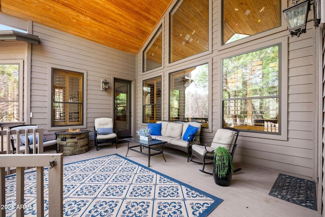sunroom / solarium with an outdoor living space with a fire pit