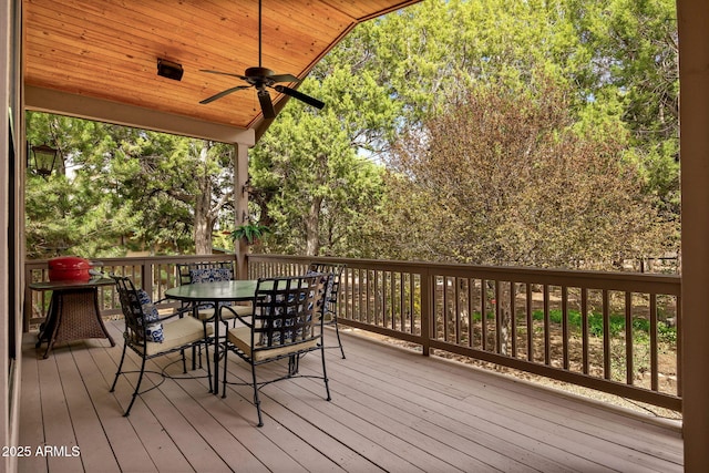 wooden terrace with a ceiling fan and outdoor dining area