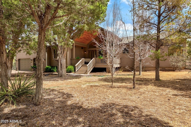 rear view of house with stairway, a garage, and crawl space