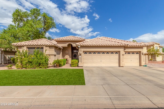 mediterranean / spanish home featuring a front lawn and a garage