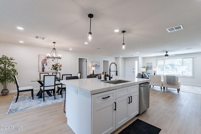 kitchen featuring sink, stainless steel dishwasher, a kitchen island with sink, white cabinetry, and light hardwood / wood-style floors