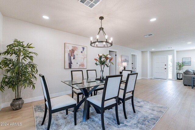 dining space featuring light hardwood / wood-style flooring and a chandelier