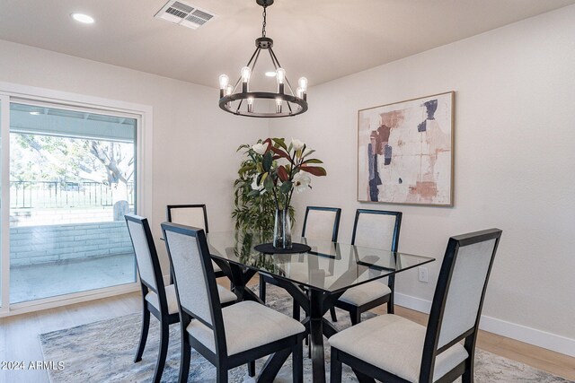 dining room featuring light wood-type flooring and an inviting chandelier