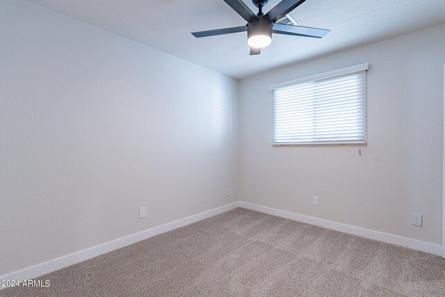 carpeted spare room featuring ceiling fan