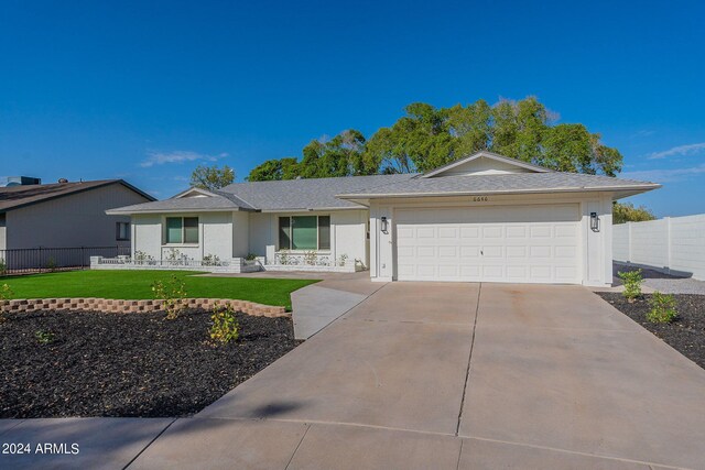 single story home with a garage and a front lawn