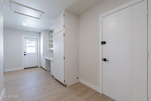 interior space with a textured ceiling and light hardwood / wood-style floors