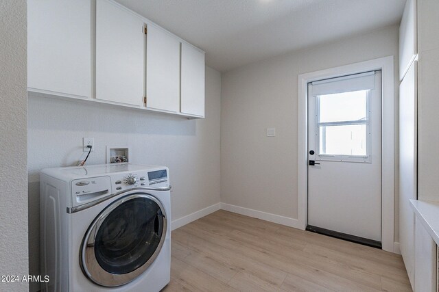 washroom featuring cabinets, washer / dryer, and light hardwood / wood-style flooring