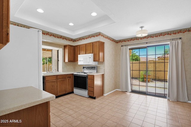9797 N 100th Pl, Scottsdale, AZ 85258 - kitchen featuring white appliances, light countertops, recessed lighting, brown cabinetry, and a tray ceiling