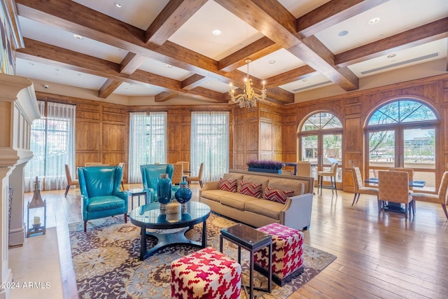 living room with a notable chandelier, wooden walls, and coffered ceiling