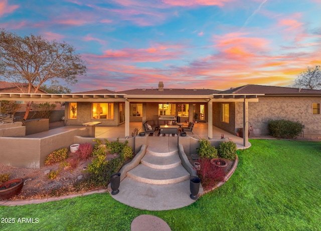 back house at dusk featuring a yard, an outdoor hangout area, and a patio