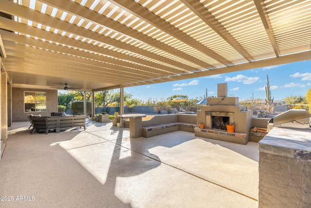 view of patio / terrace with ceiling fan, an outdoor living space with a fireplace, and an outdoor kitchen