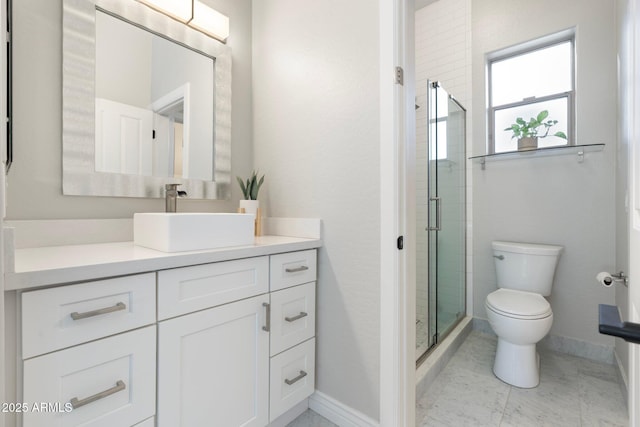 bathroom with vanity, toilet, and a shower with door