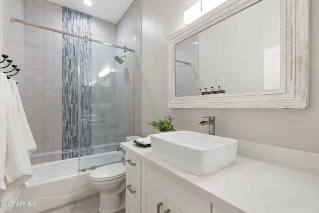 full bathroom featuring vanity, combined bath / shower with glass door, and toilet