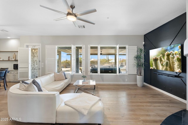 living room featuring light hardwood / wood-style flooring, plenty of natural light, and ceiling fan