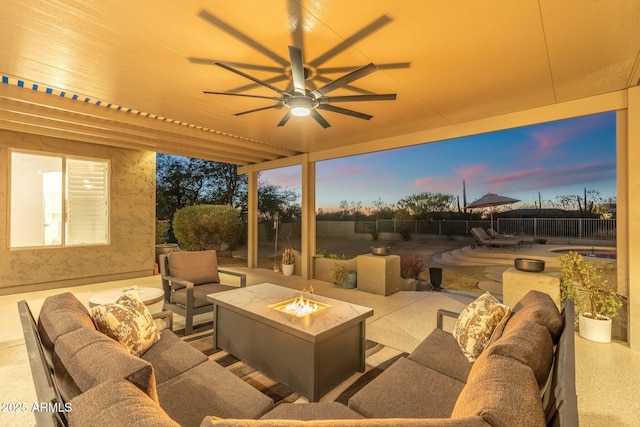 patio terrace at dusk featuring an outdoor living space with a fire pit and ceiling fan