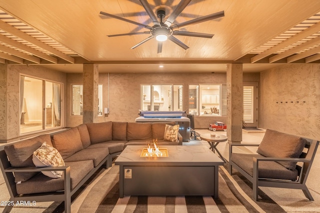 interior space featuring ceiling fan and an outdoor living space with a fire pit