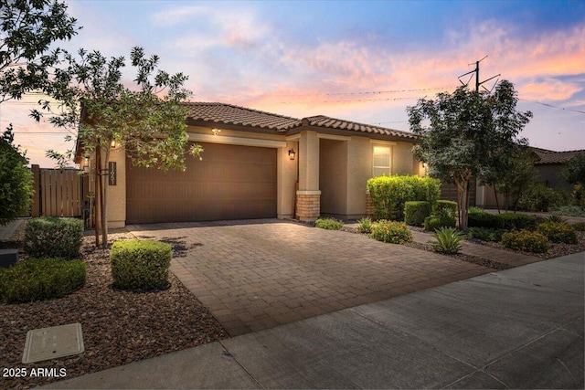 11951 W Wier Ave, Avondale, AZ 85323 - mediterranean / spanish home featuring driveway, an attached garage, stucco siding, and a tiled roof