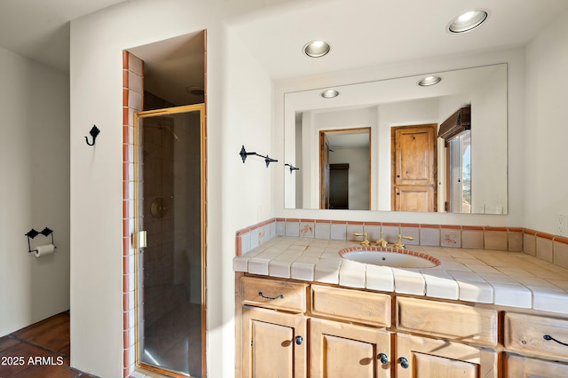 bathroom featuring vanity and a shower with door