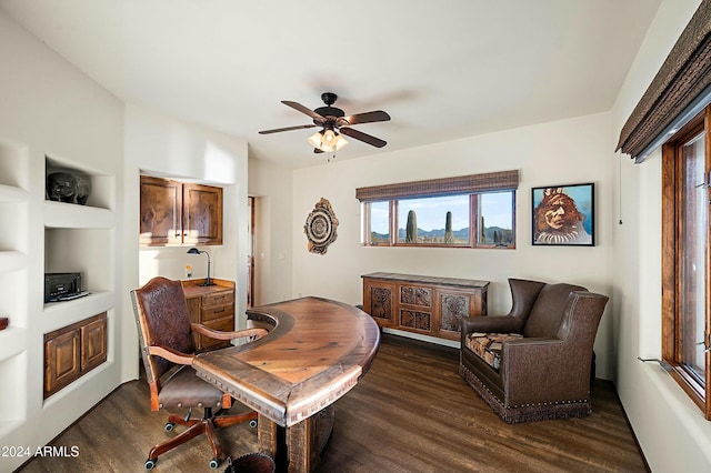 home office featuring built in shelves, ceiling fan, and dark hardwood / wood-style floors