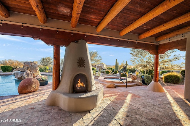 view of patio with pool water feature, a swimming pool with hot tub, and a fireplace